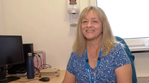 Dr Kathryn Medcalf sitting at a desk