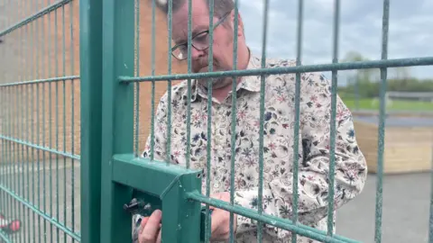Head teacher Gareth Lewis locking the school gates