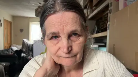 Jozef Hall/BBC Val Hodson sitting in her front room