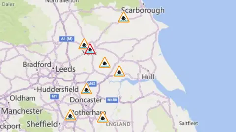 Environment Agency A map of Yorkshire showing several flood alerts and one flood warning. The map highlights key towns including Leeds, Bradford, Huddersfield, Doncaster, Rotherham, Hull and Scarborough.