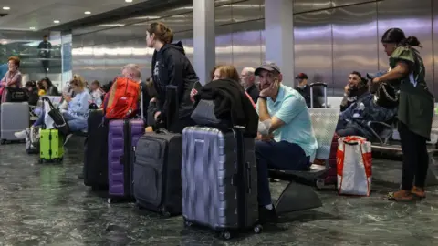 Getty Images Travellers wait for trains at Euston Station during June's RMT strikes