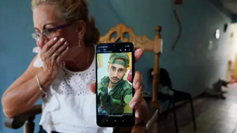 REUTERS/Alexandre Meneghini Last year, Marilin Vinent showed a photo of her son Dannys in a Russian uniform, saying he had gone to Russia to work in construction.