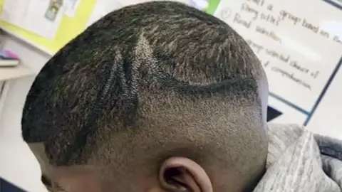 AFP PHOTO / KALLINEN LAW PLCC/HANDOUT A teenager, showed with his faded hair style coloured in with a black marker pen by school officials