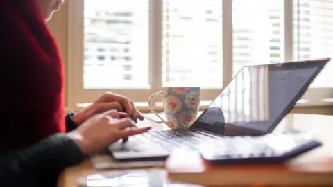 PA Media Woman working on a laptop computer