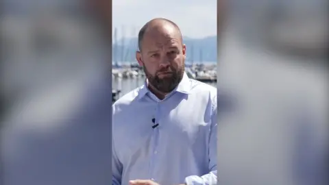 BBC Correspondent James Waterhouse wearing pale blue shirt