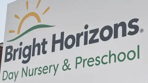 BBC/Harry Low Bright Horizons day nursery and preschool sign in black and green writing with sun logo above its text