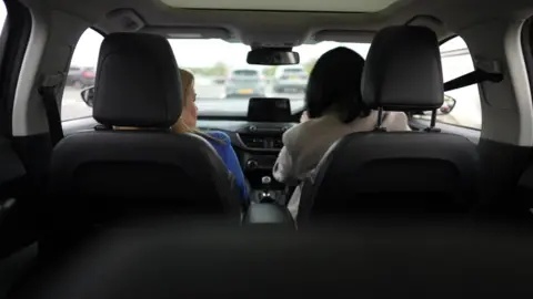 BBC 'Lisa' driving with June Kelly in passenger seat