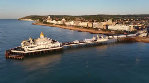 Darryl Curd an ariel view of eastbourne pier. the pier is on the sea. buildings on the sea front.