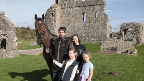 Charlotte, Christian and their daughters Betsy and Tilly with Kitty's Light in the grounds of Ogmore Castle