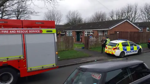 A fire engine and police car at the scene of the fire in a ground floor flat in Oldham