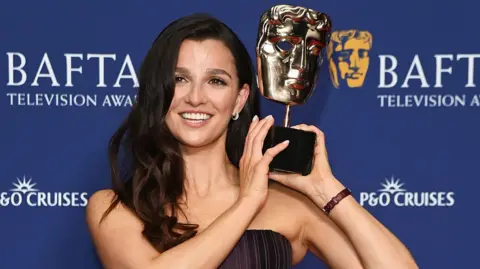 Marisa Abela, winner of the Leading Actress Award for 'Industry', lifts her Bafta on Sunday
