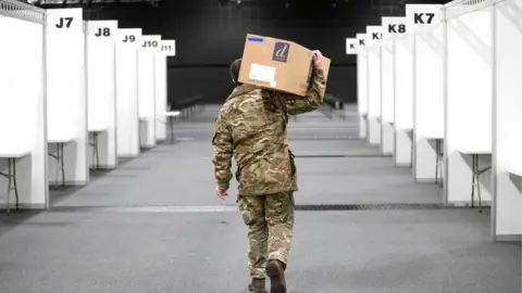 PA Media A member of the Royal Scots Dragoon Guard helps set up a mass vaccination centre at the P&J Live Arena in Aberdeen