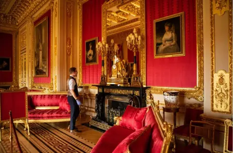 Antonio Olmos Fjodor stands in a large gold and red state apartment