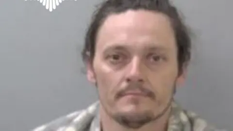 West Mercia Police A blurred image of a man with brown hair and a beard in front of a grey background