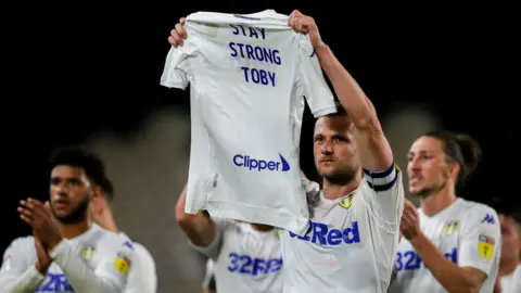 Getty Images Liam Cooper holds up a shirt in support of toby