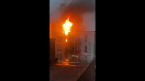 Large flames burn multiple flats in a building