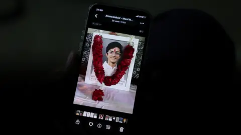 Prashant Patel, 45, shows a photo of his 17-year-old son Kahaan Patel, who took his own life ahead of the NEET exam retest, in Ahmedabad, India, July 21, 2026. REUTERS/Amit Dave