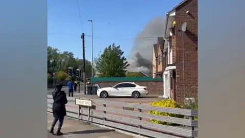 Supplied A large plume of smoke rises above some residential streets