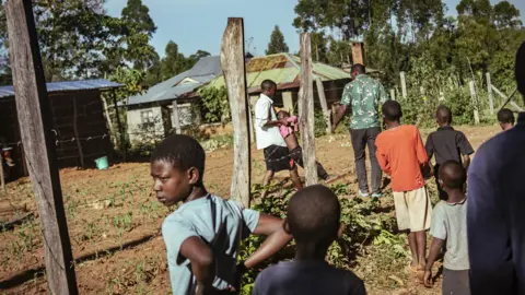 Duncan Moore People look on as a girl knocked over by a bull is carried away in western Kenya