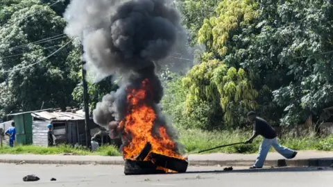 EPA A protester burns tires during a protest during the inauguration of Mozambique's fifth president, Daniel Chapo, in Maputo, Mozambique, 15 January 2025