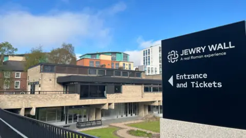 The Jewry Wall Roman museum behind a black sign 