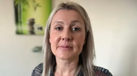 Emma Baugh/BBC News A woman with a peaceful scene picture in the background