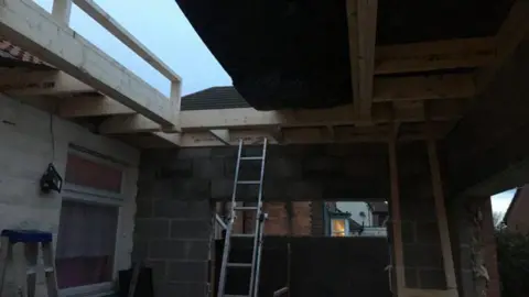 A photo of the scene of the accident, with a ladder propped up leading to roof beams