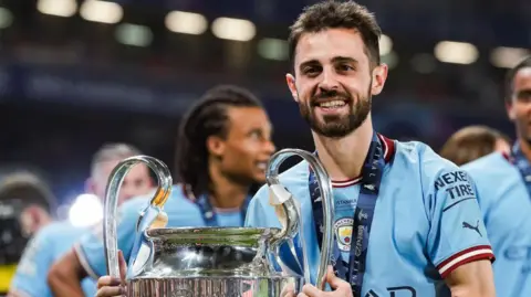 Bernardo Silva holding the Champions League trophy in 2023