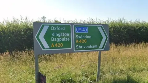 Google Road signs: on the left pointing to Oxford and Kingston Bagpuize, on the right Swindon and Shrivenham.
