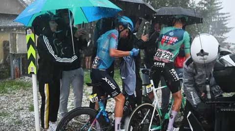 Tim de Waele/Getty Images Lorenzo Fortunato of Italy and Team XDS Astana and Mats Wenzel of Luxembourg and Team Equipo Kern Pharma react after the cancellation of the stage due to a hailstorm during the La Vuelta - 81st Tour of Spain 2026, Stage 3 a 174km from Gruissan - Aude to Font Romeu 