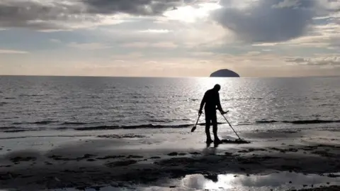 SARAH HARRIS Bernard Harris metal detecting on Girvan Beach.