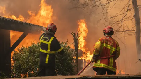 A firefighting crew deployed to battle a wildfire spreading in Lege-Cap-Ferret, south western France, late 24 July 2026.