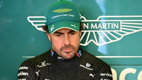 Fernando Alonso stood in the Aston Martin garage at the Australian Grand Prix