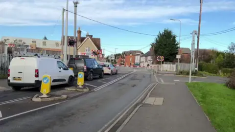 Two cars and a van queue at the London Road level crossing in Bicester.