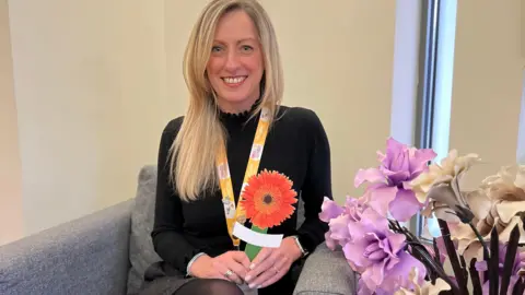 St Giles Hospice Ali Callear holding Gerbera flower peg