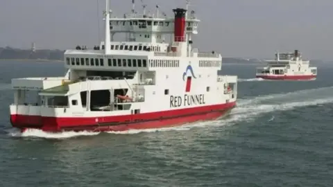 Two Red Funnel Isle of Wight ferries, with red and white livery, passing on Southampton Water