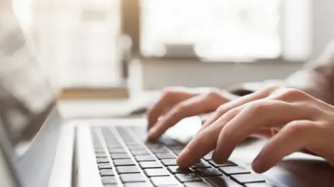 Anonymous fingers tapping away on a computer keyboard