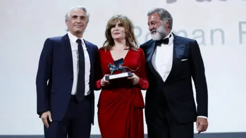 Getty Images Producer Alain Goldman, actor Emmanuelle Seigner and co-producer Luca Barbareschi accepted the award for An Officer and a Spy at Venice Film Festival, 7 September 2019