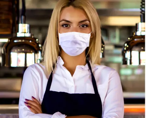 Getty Images Young waitress in coffee shop