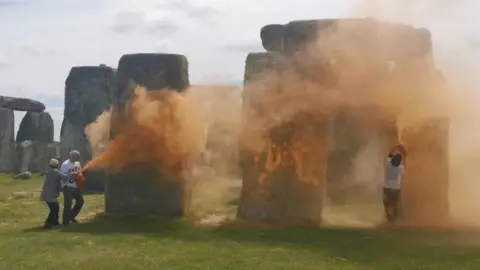 JUST STOP OIL Just Stop Oil activists spraying orange powder paint at Stonehenge on 19 June 2024