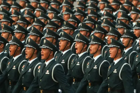 Getty Images Soldiers of the People's Liberation Army shout during the rehearsal of the parade on the morning of 1 October 2019, in Tiananmen Square, Beijing.