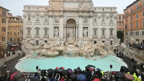 Getty Images Pemandangan umum menunjukkan air mancur Trevi setelah pekerjaan renovasi di Roma, pada hari pembukaannya kembali dengan kerumunan orang berkerumun di sekitar pembukaan kembali.