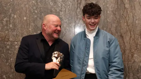 Mark Herbert and Owen Cooper backstage with the Limited Drama Award for Adolescence during the 2026 BAFTA Television Awards