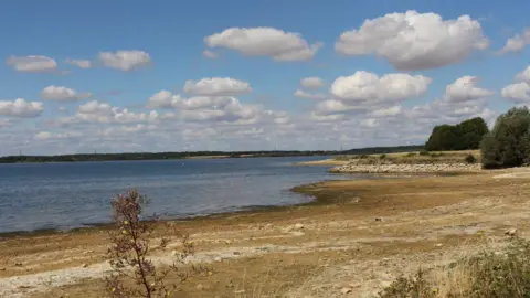 A large reservoir of water with long, dry banks around the edges.
