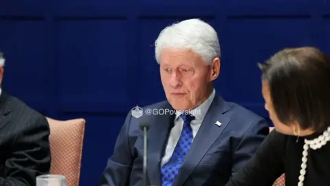 Bill Clinton is seen sitting down.