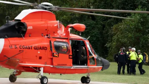 Getty Images A US Coast Guard helicopter lands near Davistown, North Carolina in the aftermath of Hurricane Helene