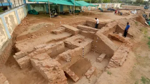 Bhakarba Thakor The photograph shows the site where the skeleton was discovered, with a shed in the background and a few men inspecting the area.