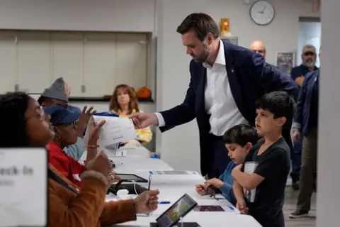 Carolyn Kaster/AP Republican vice-presidential nominee Sen JD Vance, R-Ohio, and children, arrives to vote at the St Anthony of Padua Maronite Catholic Church on election day, Tuesday 5 November 2024, in Cincinnati