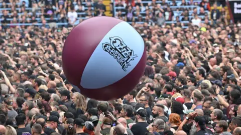 Getty Images A claret and white beach-ball which says Ozzy Osbourne bounces over a crowd of concert-goers at the gig.