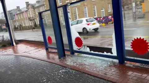 Dusty Chelmsford A smashed glass pane outside New Again Auto Reconditioning